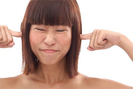 Young woman sticking fingers into her ears Stock Photo - Premium Royalty-Free, Code: 656-01773881