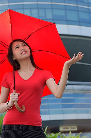 rainy day sad - Woman with red umbrella, looking up, frowning Stock Photo - Premium Royalty-Free, Code: 656-01773906