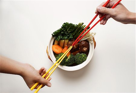 hands holding chopsticks in clay pot of vegetables Stock Photo - Premium Royalty-Free, Code: 656-02702855