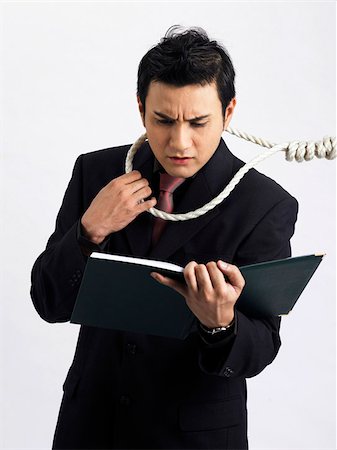 dangerous accident - man holding work file with a rope around his neck Stock Photo - Premium Royalty-Free, Code: 656-02879555