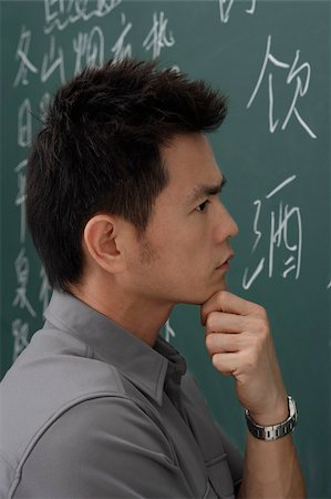 portrait of man thinking in front of chalk board Stock Photo - Premium Royalty-Free, Code: 656-02879647
