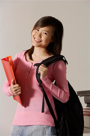 Young woman carrying back pack and folder. Stock Photo - Premium Royalty-Free, Code: 656-03076308
