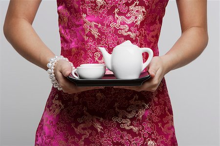 singapore traditional costume lady - cropped shot of woman wearing pink cheongsam holding tea Stock Photo - Premium Royalty-Free, Code: 656-03076321