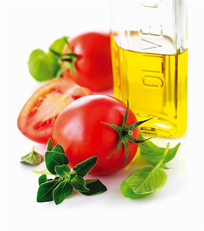 Tomatoes, a bottle of olive oil and fresh herbs (close-up) Stock Photo - Premium Royalty-Free, Code: 659-06154669