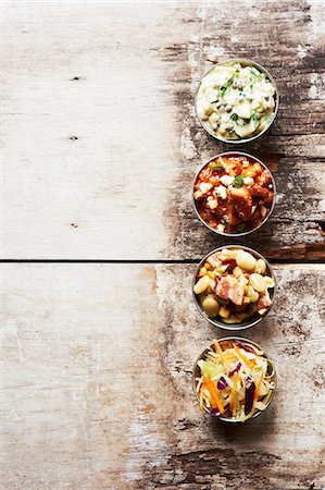 Plats d'accompagnement barbecue dans des petits bols sur une Table en bois ; Porc et haricots, salade de pommes de terre, salade de chou et Succotash Photographie de stock - Premium Libres de Droits, Code: 659-06154967