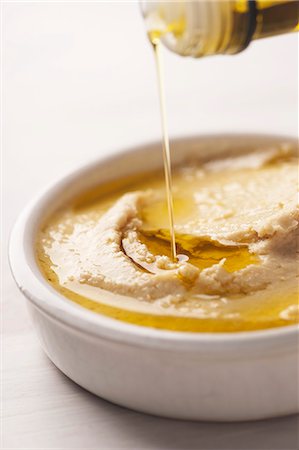 Olive oil being pored over hummus Stock Photo - Premium Royalty-Free, Code: 659-06155000