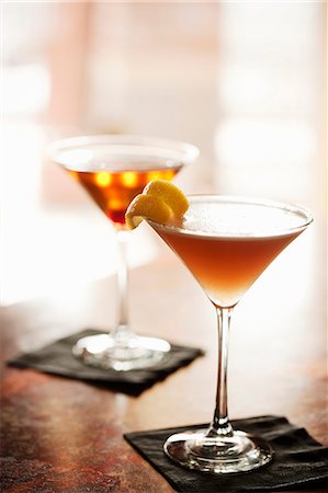 Two Cocktails in Stem Glasses on a Bar (Aviation Cocktail and Manhattan) Stock Photo - Premium Royalty-Free, Code: 659-06155163