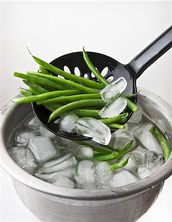 Quenched beans being removed from a bowl of iced water Stock Photo - Premium Royalty-Free, Code: 659-06155776