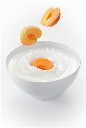 Apricots falling into a bowl of yogurt Stock Photo - Premium Royalty-Free, Code: 659-06152055