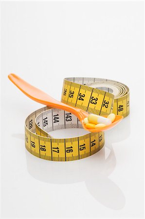 slim - Pills on a spoon with a measuring tape Stock Photo - Premium Royalty-Free, Code: 659-06152273