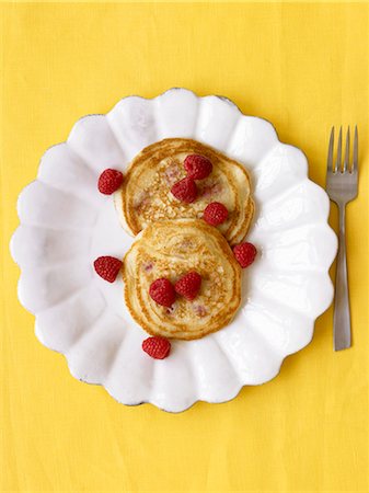 pancake - Two Pancakes with Fresh Raspberries on a White Plate; Yellow Background Stock Photo - Premium Royalty-Free, Code: 659-06152371