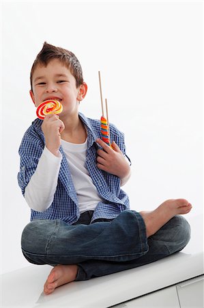 student (male) - A little boy eating a lolly Stock Photo - Premium Royalty-Free, Code: 659-06153336