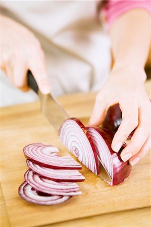 Woman Slicing Red Onion on Cutting Board Stock Photo - Premium Royalty-Free, Code: 659-06153463