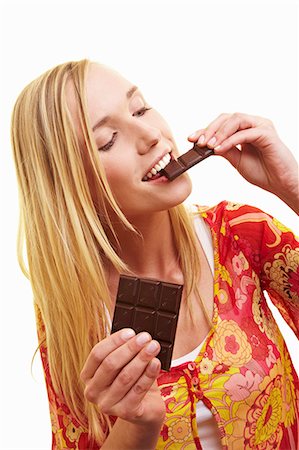 A young woman biting a piece of dark chocolate Stock Photo - Premium Royalty-Free, Code: 659-06184004