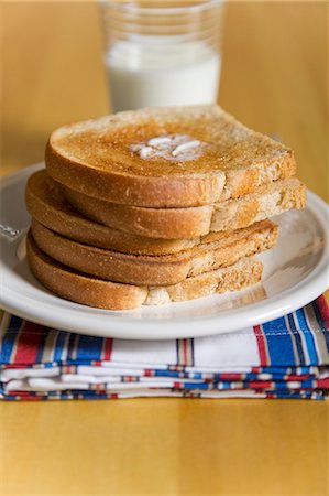Stack of Buttered Toast on a White Plate; Glass of Milk Stock Photo - Premium Royalty-Free, Code: 659-06185498
