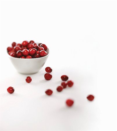 simsearch:659-07027144,k - Fresh Cranberries in and Around a White Bowl; White Background Stock Photo - Premium Royalty-Free, Code: 659-06186443