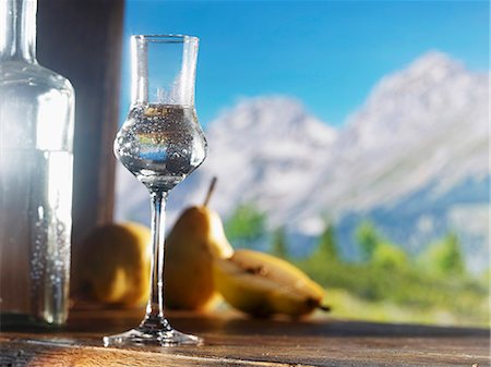 A glass of William's pear schnapps against an alpine backdrop Stock Photo - Premium Royalty-Free, Code: 659-06187081