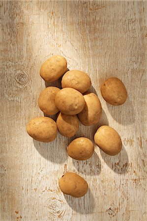 raw potato - Potatoes on a wooden surface (seen from above) Stock Photo - Premium Royalty-Free, Code: 659-06187254