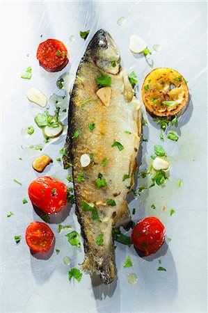 Fried trout with herbs, garlic, tomatoes and lemons Stock Photo - Premium Royalty-Free, Code: 659-06187282