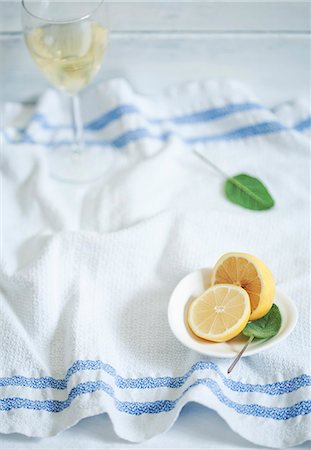 simsearch:659-06186663,k - Fresh lemon, sage and a glass of white wine on a kitchen towel Stock Photo - Premium Royalty-Free, Code: 659-06187373