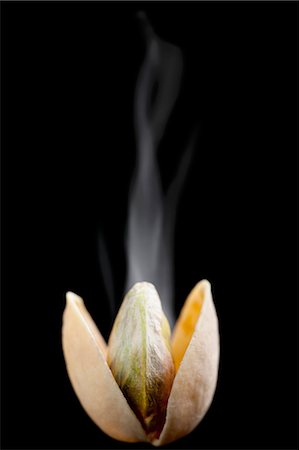 A steaming, opened, toasted pistachio against a black background Stock Photo - Premium Royalty-Free, Code: 659-06187990