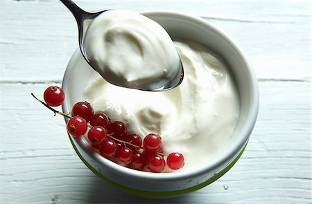 A bowl and a spoonful of yogurt with fresh redcurrants Stock Photo - Premium Royalty-Free, Code: 659-06188180