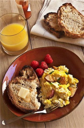 Eggs and Potatoes on a Plate with Buttered Toast and Raspberries; Orange Juice and Tabasco Sauce Stock Photo - Premium Royalty-Free, Code: 659-06188433