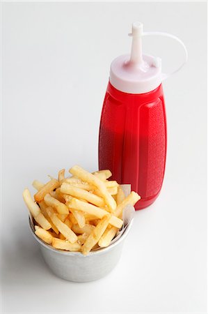 fries - A bowl of chips and a bottle of ketchup Stock Photo - Premium Royalty-Free, Code: 659-06306939