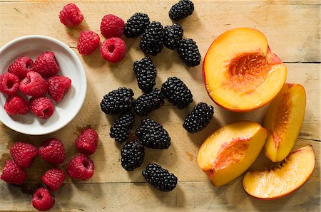 simsearch:659-08419643,k - Fresh Raspberries, Blackberries and Peaches on Wooden Surface; From Above Stock Photo - Premium Royalty-Free, Code: 659-06307280