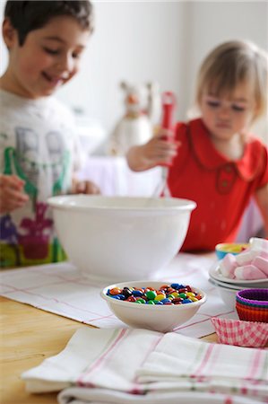 Young boy and girl mixing ingredients for cupcakes in a bowl Stock Photo - Premium Royalty-Free, Code: 659-06372513