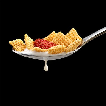 Corn Square Cereal with a Strawberry in a Spoon with Milk Dripping; Black Background Stock Photo - Premium Royalty-Free, Code: 659-06372930