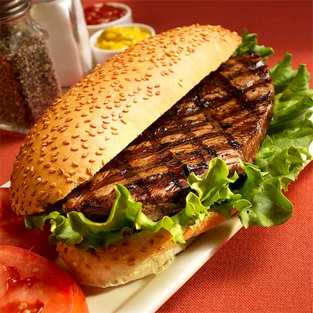 Grilled Steak Sandwich on a Sesame Seed Bun with Lettuce Stock Photo - Premium Royalty-Free, Code: 659-06373059