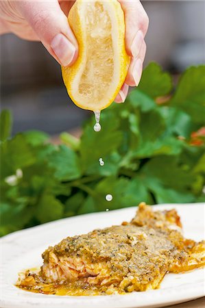 single lemon - Salmon trout with a herb crust being drizzled with lemon juice Stock Photo - Premium Royalty-Free, Code: 659-06373337