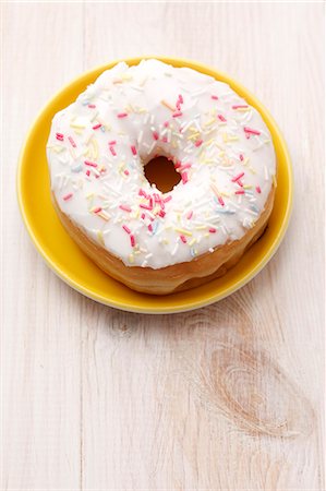 frosted - An iced doughnut with sugar sprinkles Stock Photo - Premium Royalty-Free, Code: 659-06373534