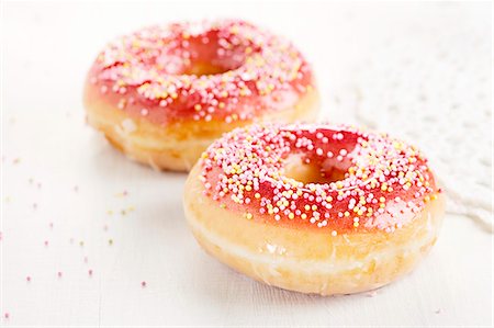 simsearch:659-06373404,k - Two doughnuts with a red sugar glaze and sprinkles Stock Photo - Premium Royalty-Free, Code: 659-06373751
