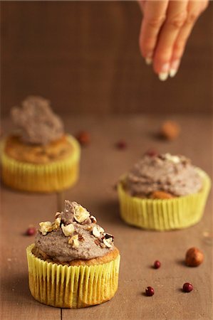 simsearch:659-06903190,k - Cupcakes being decorated with sweet bean cream and caramelised nuts Stock Photo - Premium Royalty-Free, Code: 659-06495442