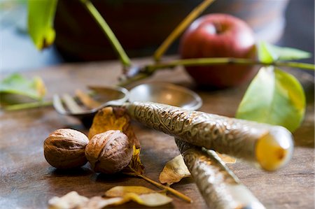An arrangement of walnuts and cutlery with an apple in the background Stock Photo - Premium Royalty-Free, Code: 659-06495495