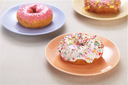 frosted - Doughnuts with colourful glaze and sugar sprinkles Stock Photo - Premium Royalty-Free, Code: 659-06493697