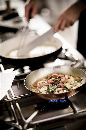 restaurant people - A chef preparing a dish in a restaurant kitchen Foto de stock - Sin royalties Premium, Código: 659-06671146