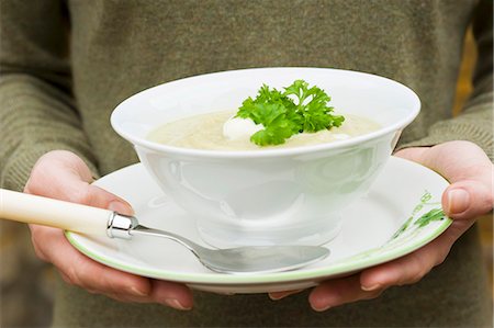 parsley - A woman holding a bowl of celery soup with crème fraîche and parsley Stock Photo - Premium Royalty-Free, Code: 659-06671382