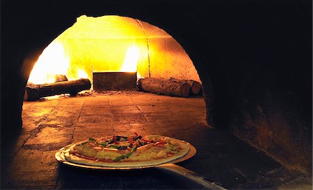 fire (things burning controlled) - A pizza being placed in a wood-fired oven Stock Photo - Premium Royalty-Free, Code: 659-06901633