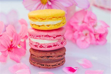 Stacked macarons (chocolate, strawberry, lemon) in front of pink flowers Foto de stock - Sin royalties Premium, Código: 659-06902177