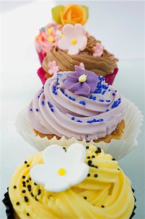 simsearch:659-06903190,k - close up, selective focus of a row of coloured cup cakes, decorated with orange, pink and purple flowers on top Stock Photo - Premium Royalty-Free, Code: 659-06903191