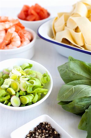 Ingredients ready for cooking, cracked black pepper, fresh basil, cooked peeled king prawns, peeled deseeded and diced tomatoes and fresh pasta Stock Photo - Premium Royalty-Free, Code: 659-06903529