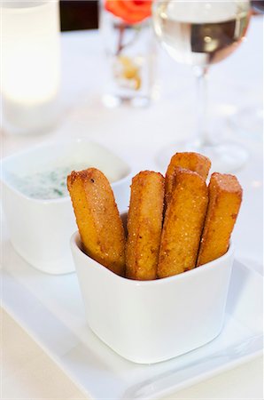 Polenta Fries Standing in a White Dish with a Dish of Dipping Sauce; White Wine Stock Photo - Premium Royalty-Free, Code: 659-06903742