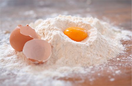 flour - An egg yolk and an egg shell in flour on a wooden slab Stock Photo - Premium Royalty-Free, Code: 659-07026940