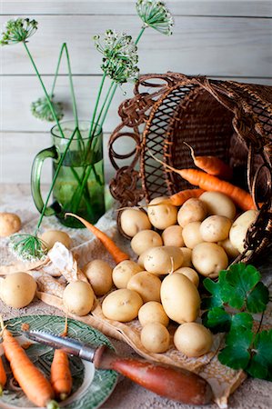 Fresh Potatoes and Carrots Spilling From a Basket; Peeler Stock Photo - Premium Royalty-Free, Code: 659-07027066