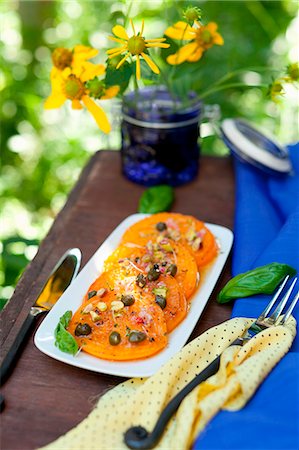simsearch:659-08940768,k - Pan Fried Yellow Tomatoes with Pistachio Caper Relish; On a Platter on an Outdoor Table Stock Photo - Premium Royalty-Free, Code: 659-07027084
