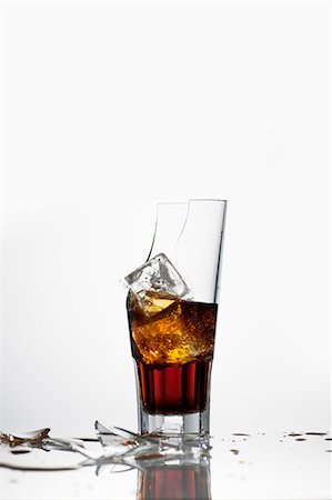A broken glass with cola and ice cubes Foto de stock - Sin royalties Premium, Código: 659-07027176