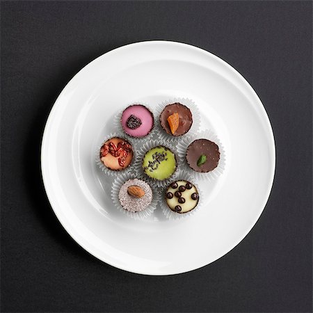 simsearch:659-07026815,k - Assorted hand-made filled chocolates on a plate (view from above) Foto de stock - Sin royalties Premium, Código: 659-07027173